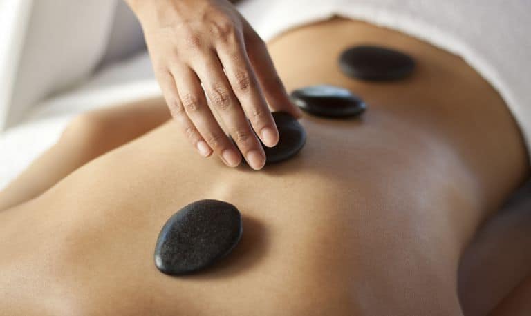 Warm stones placed along the back during a hot stone massage