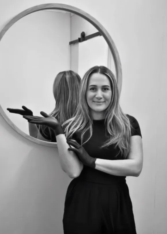 Sophie, founder of Sophie's Beauty Room, standing in front of the round mirror in the treatment room